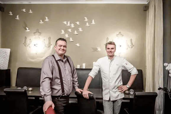 Chef and manager standing in restaurant